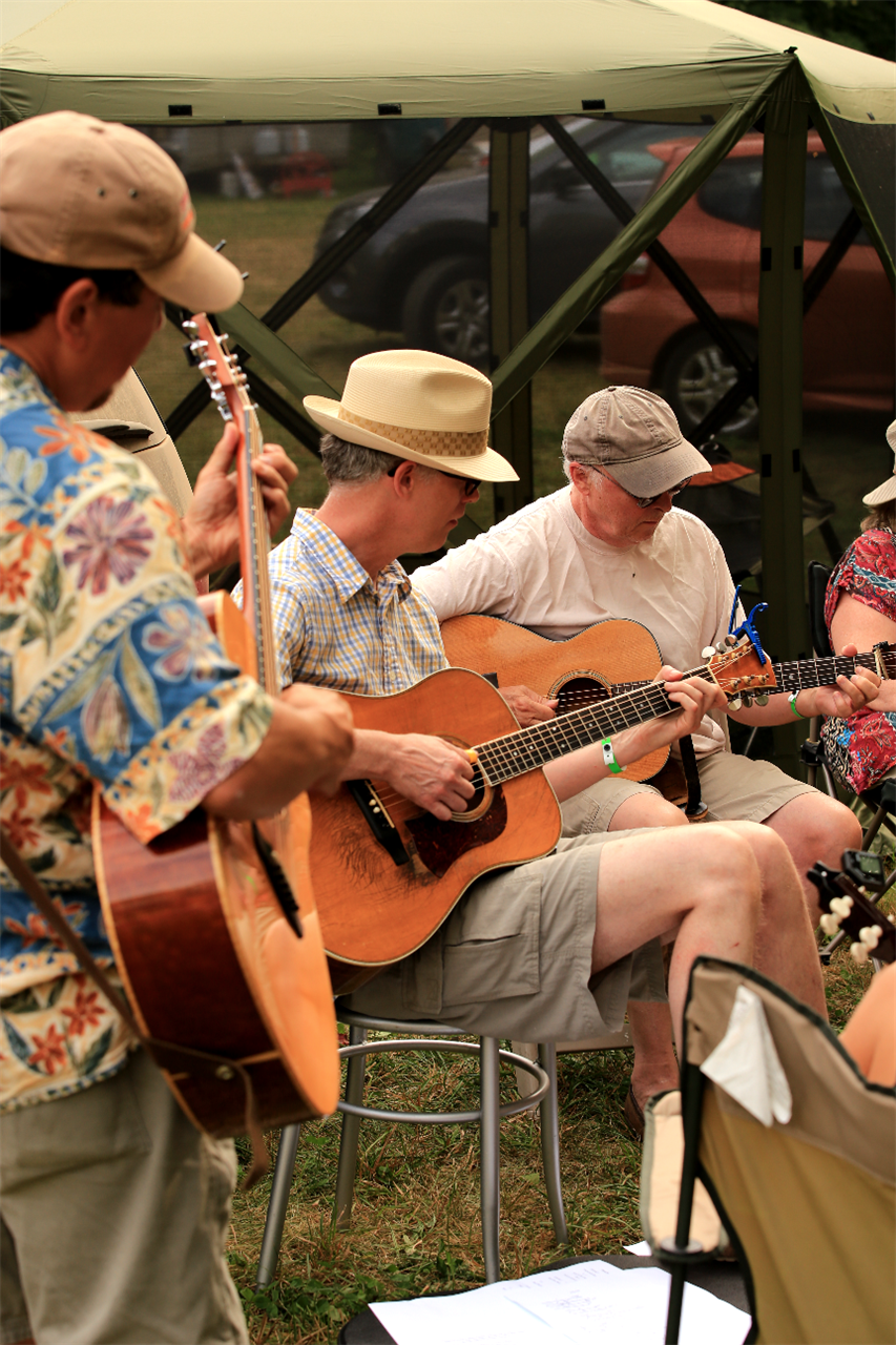 `<img alt="three men playing guitar outdoors"`>